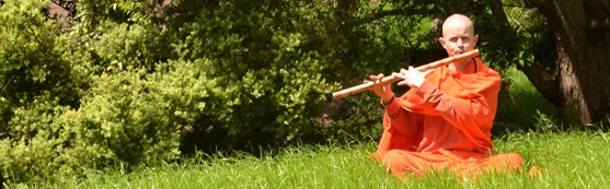 Swami playing flute in grass